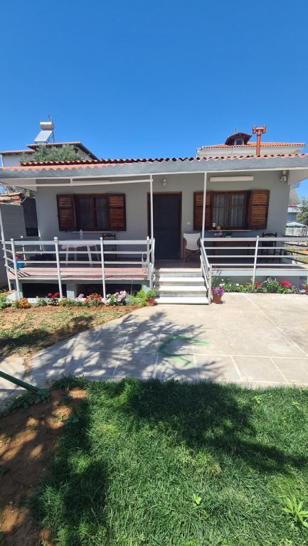 ein weißes Haus mit einer Veranda und einer Auffahrt in der Unterkunft Seaside House in Paralia Dionisiou