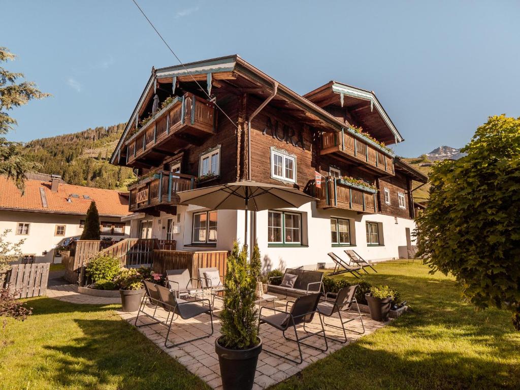 una casa con sedie e ombrellone davanti di AURA Bed & Breakfast a Sankt Jakob in Defereggen