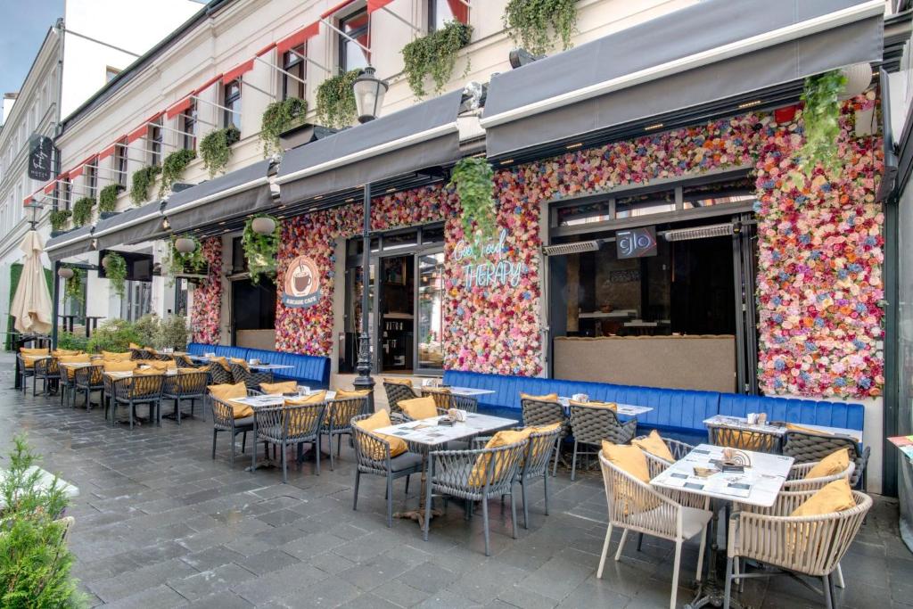 an outdoor patio with tables and chairs in front of a restaurant at Hotel Forty One in Bucharest