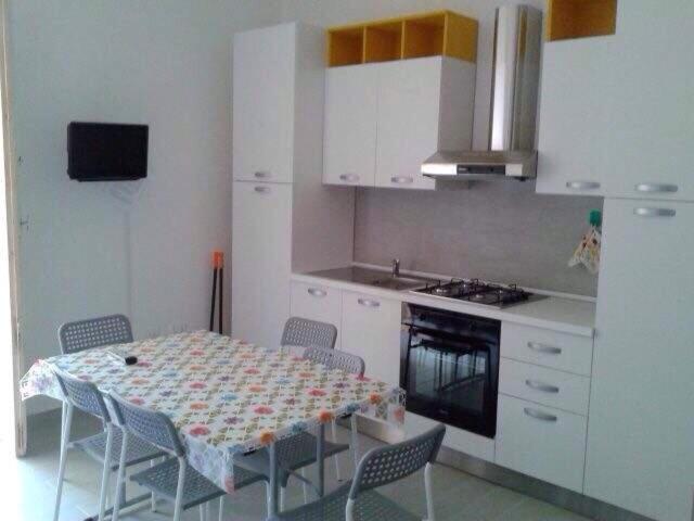 a kitchen with a table and chairs in a kitchen at Bilocale 1 - Casa Marì in Margherita di Savoia