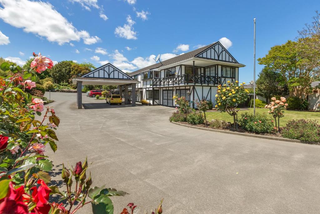 a large house with a driveway in front of it at Kingswood Manor Motel in Whangarei