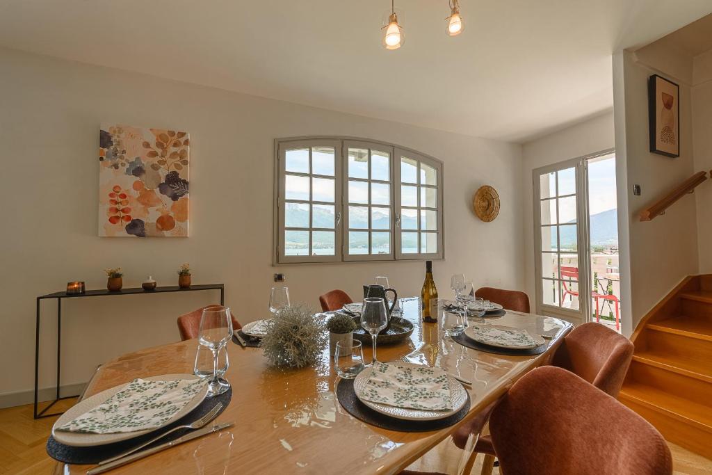 a dining room with a wooden table and chairs at Villa Signature - Vue Panoramique 9p in Sévrier