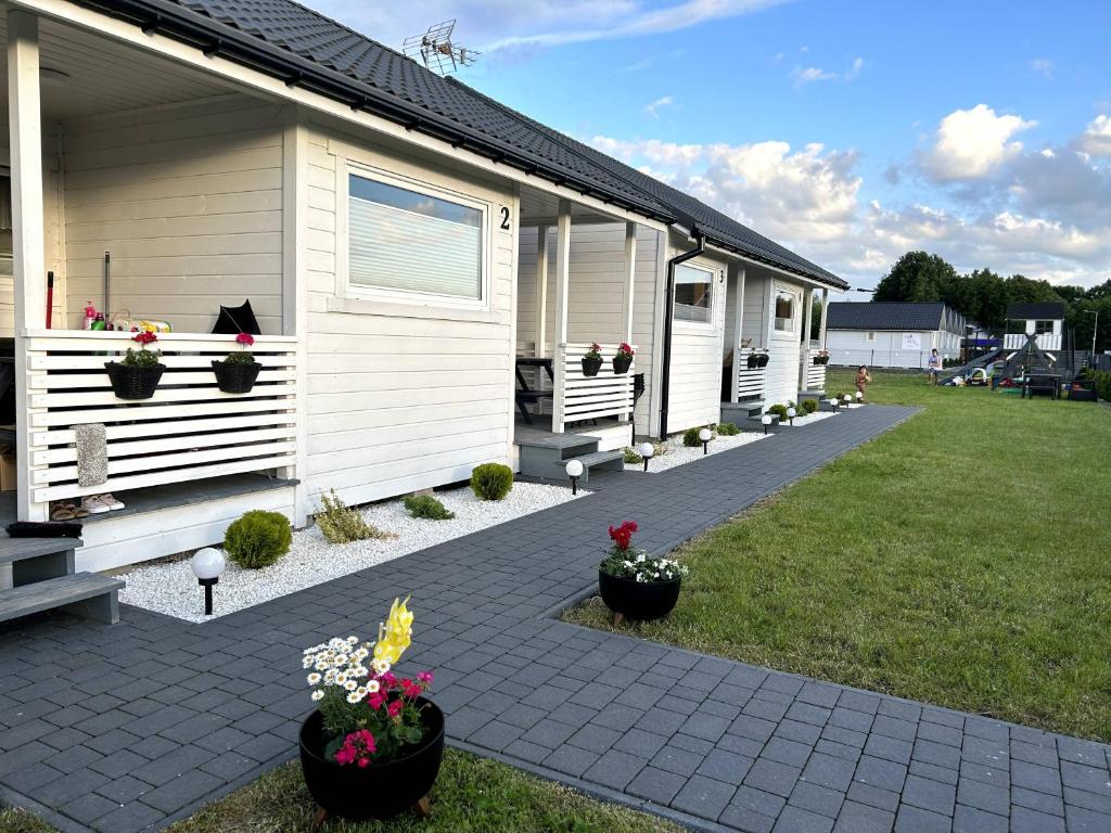 a house with flower pots on the side of it at Słoneczna Gąska in Gąski