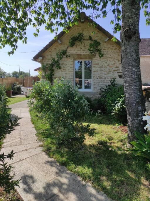 une maison en briques avec un arbre et un trottoir dans l'établissement Gite Les'Couves, à Colombiers