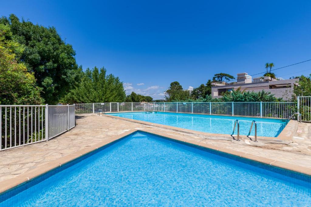 a swimming pool with a fence around it at Jolie Maison Proche Plage in Toulon