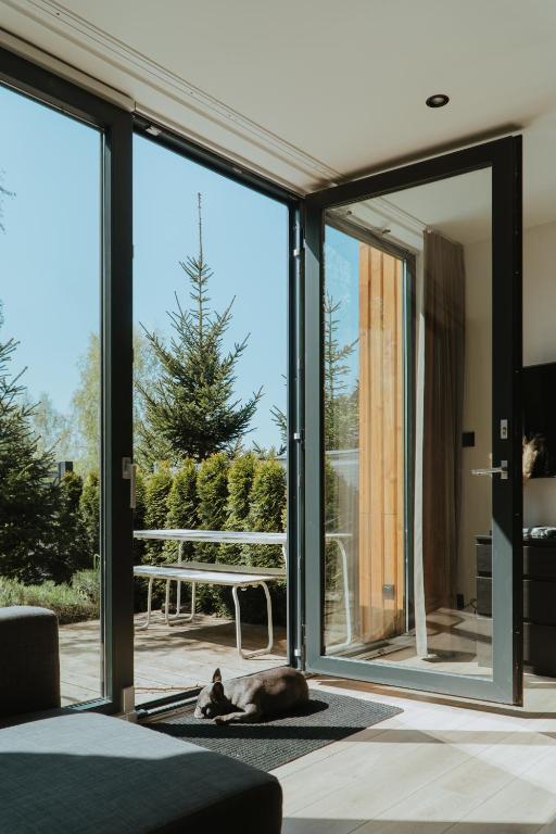 a room with sliding glass doors and a dog laying on the floor at Villa Baltica Premium in Niechorze