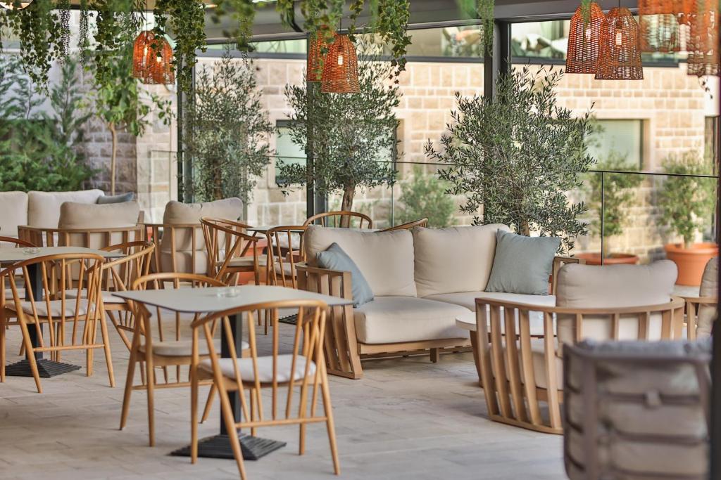 a patio with tables and chairs and a couch at Regent Resort Budva in Budva