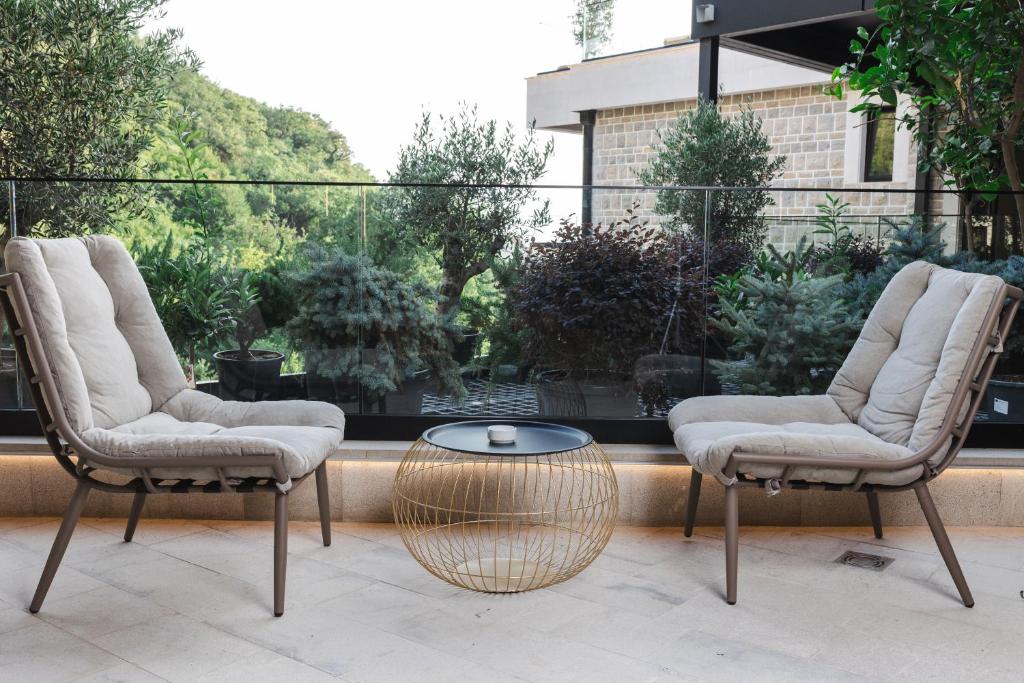 two chairs and a coffee table in front of a window at Regent Resort Budva in Budva