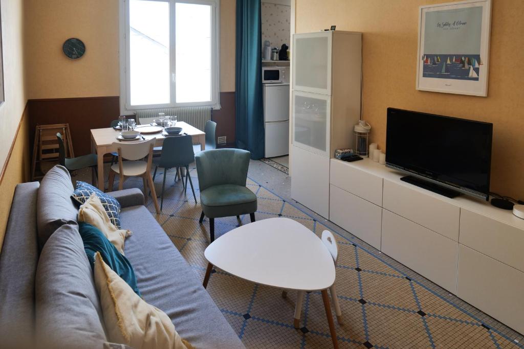 un salon avec un canapé et une télévision dans l'établissement Appartement cœur de ville entre port et plage Les Sables 6 personnes, à Les Sables-dʼOlonne
