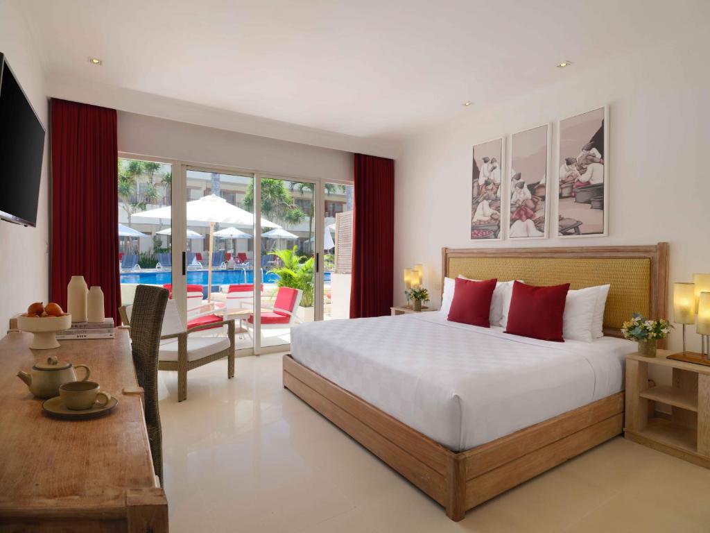 a bedroom with a bed and a living room with a patio at Blu-Zea Resort by Double-Six in Seminyak