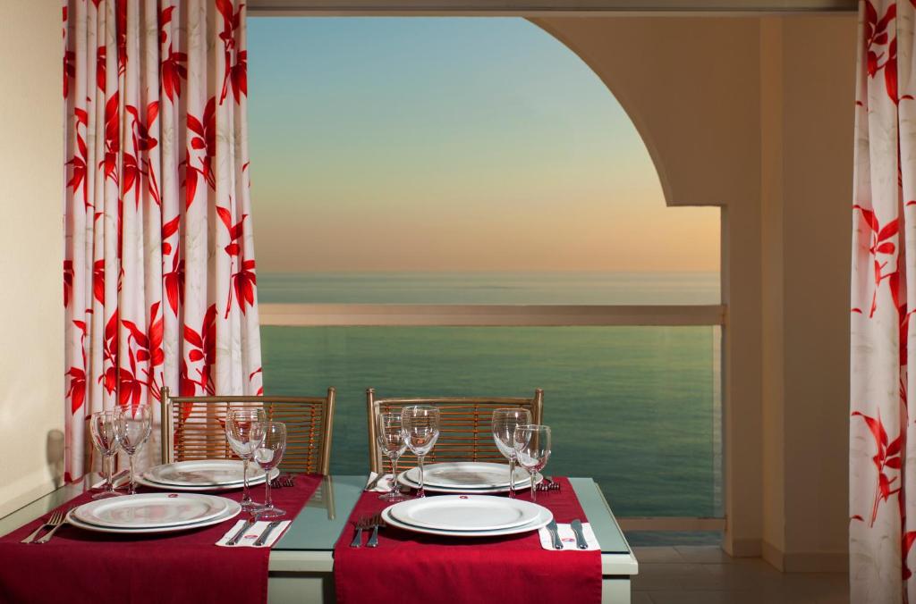 a table with chairs and wine glasses on it at Ona Marinas de Nerja Spa Resort in Nerja