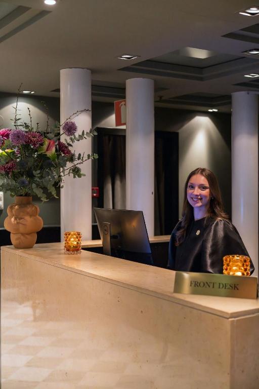 a woman sitting at a front desk in an office at Berns, Historical Boutique Hotel & House of Entertainment since 1863 in Stockholm