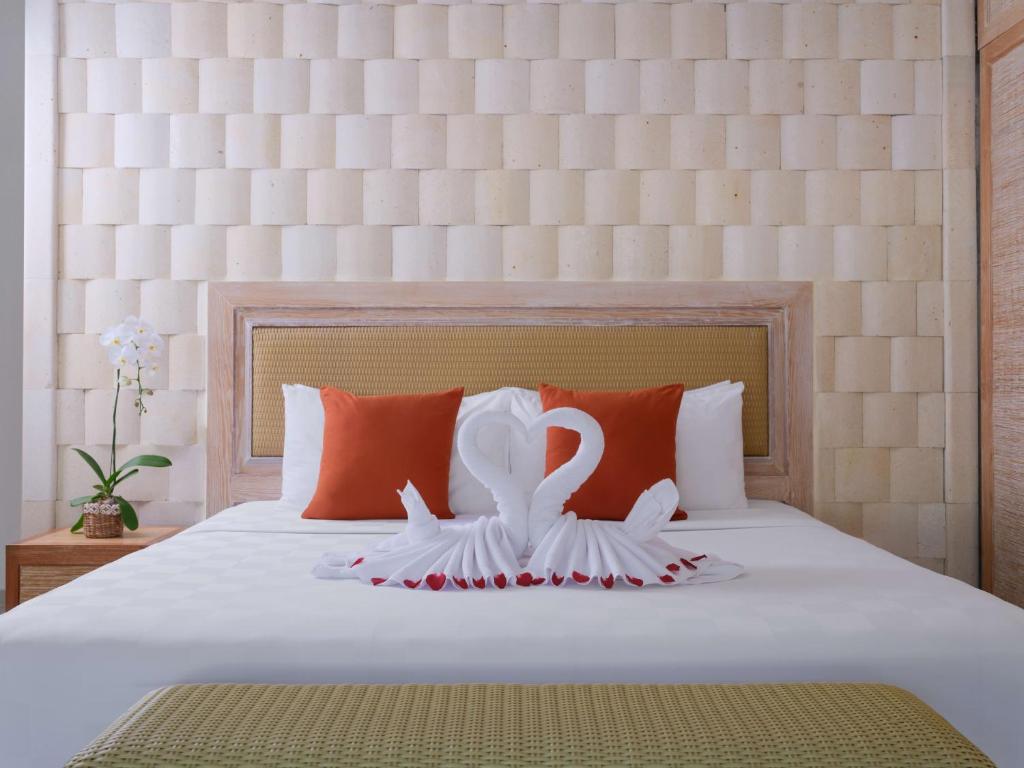 a bed with two white swans on it at Blu-Zea Resort by Double-Six in Seminyak