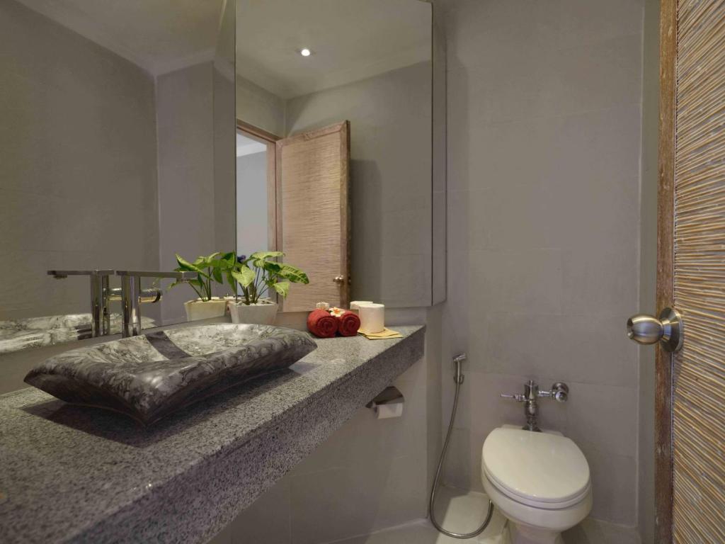 a bathroom with a toilet and a sink and a mirror at Blu-Zea Resort by Double-Six in Seminyak