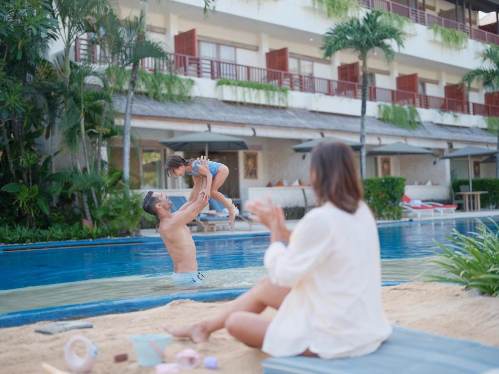 a boy and a girl playing in a swimming pool at Blu-Zea Resort by Double-Six in Seminyak
