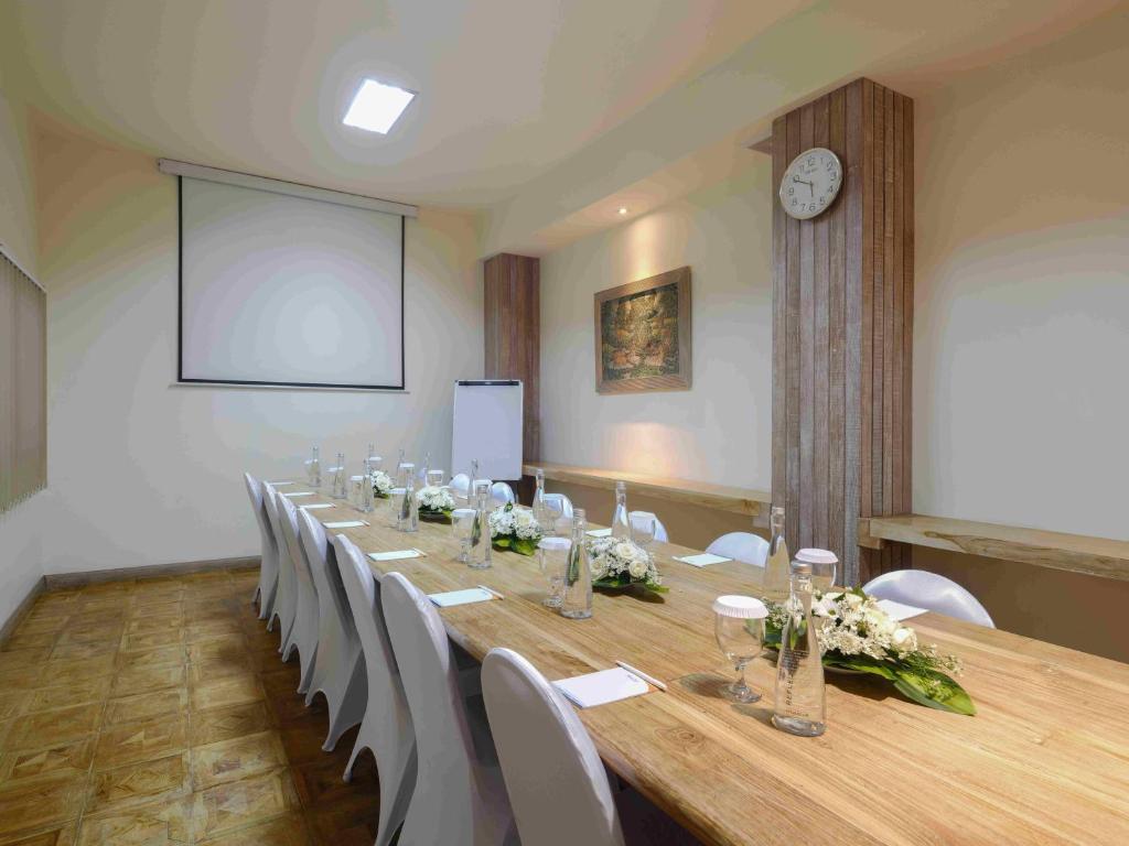 a conference room with a long table and white chairs at Blu-Zea Resort by Double-Six in Seminyak