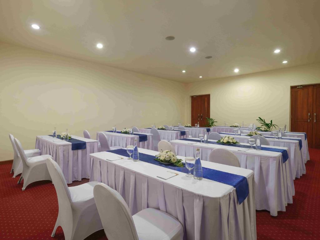a room full of tables and chairs with white table cloths at Blu-Zea Resort by Double-Six in Seminyak