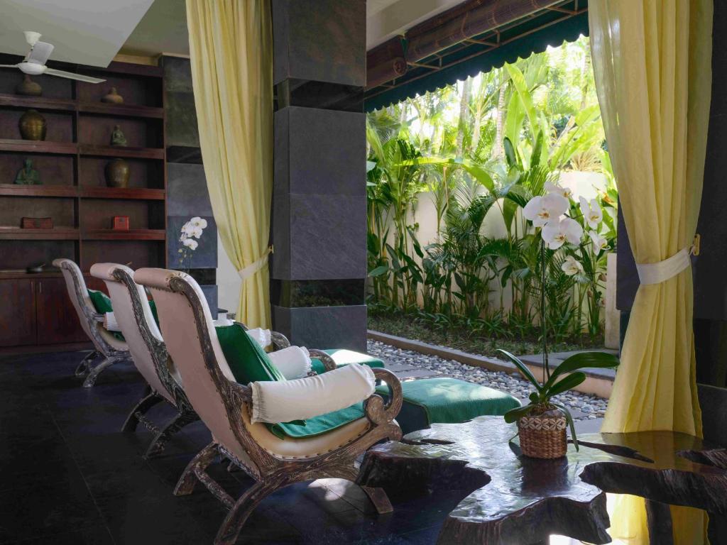 a living room with chairs and a table and a window at Blu-Zea Resort by Double-Six in Seminyak