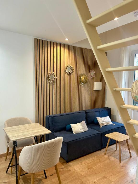 un salon avec un canapé bleu et une table dans l'établissement Le ruisseau, à Nice