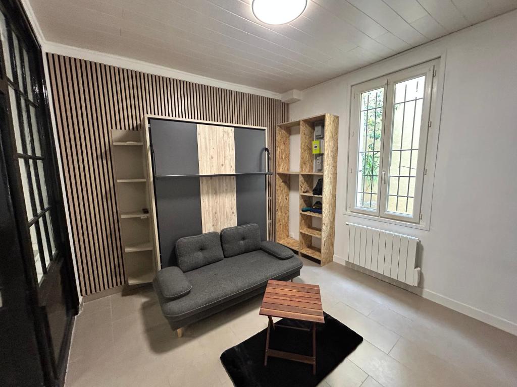 un salon avec un canapé et une table dans l'établissement petit Muguet, à Avignon