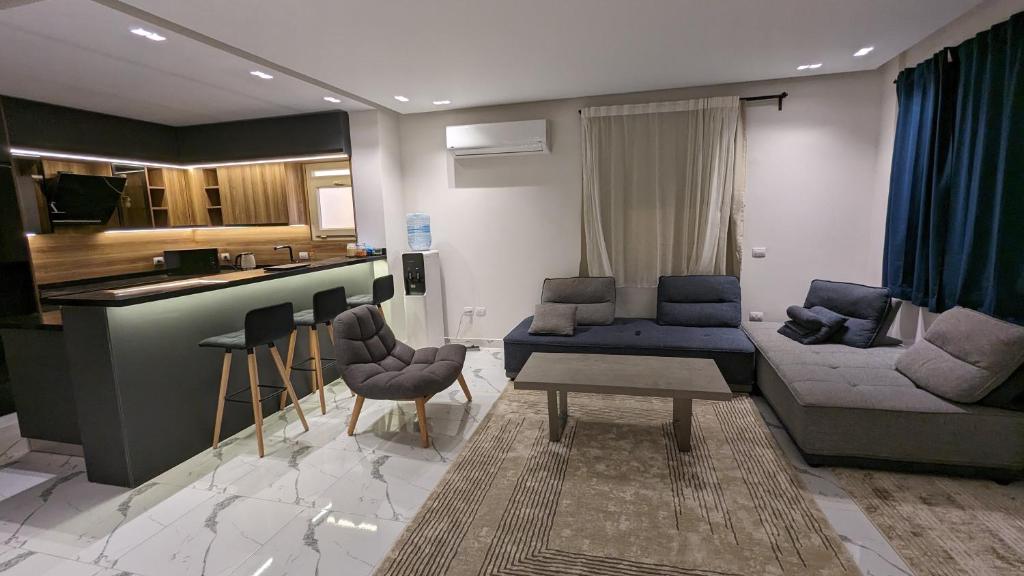 a living room with a couch and a kitchen at New Cairo Serviced Apartment in Cairo