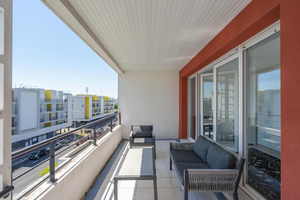 d'un balcon avec un canapé et une vue sur la ville. dans l'établissement Duplex de Charlotte près de la gare, à Royan