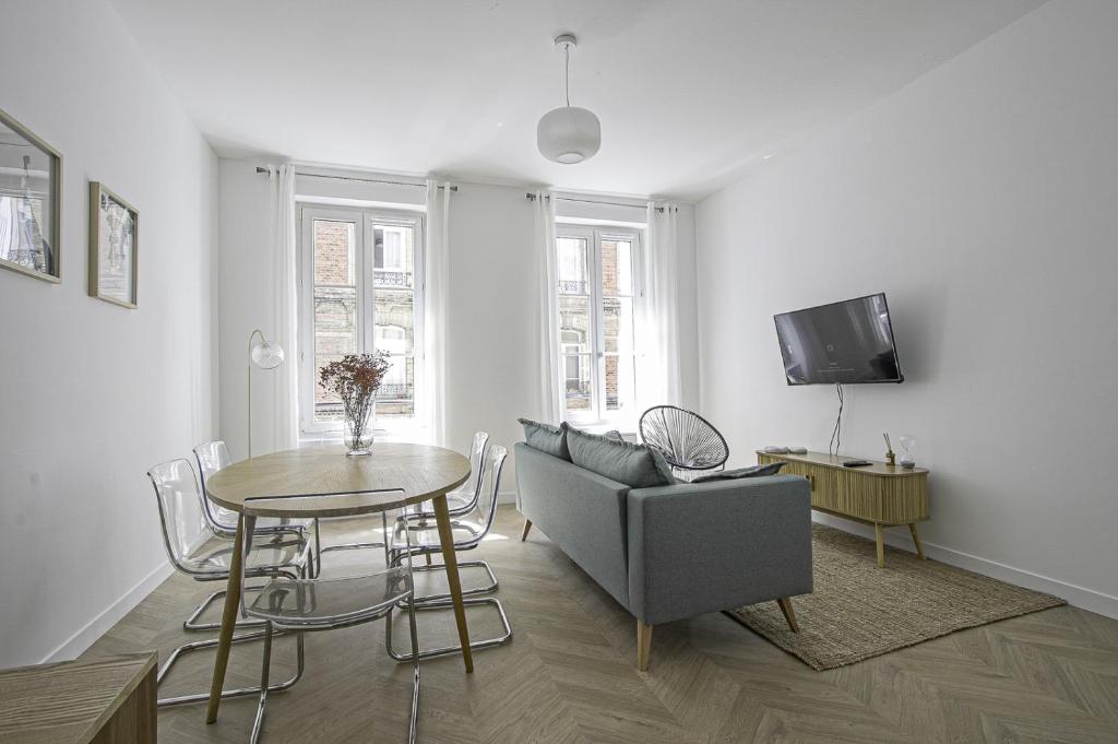 - un salon avec une table, un canapé et une télévision dans l'établissement Appartement F4 - Palais de justice - Proche gare, au Havre