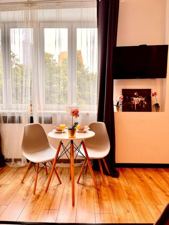 a table and chairs in a living room with a fireplace at Nice 1Room Condo WarszawaCenter in Warsaw