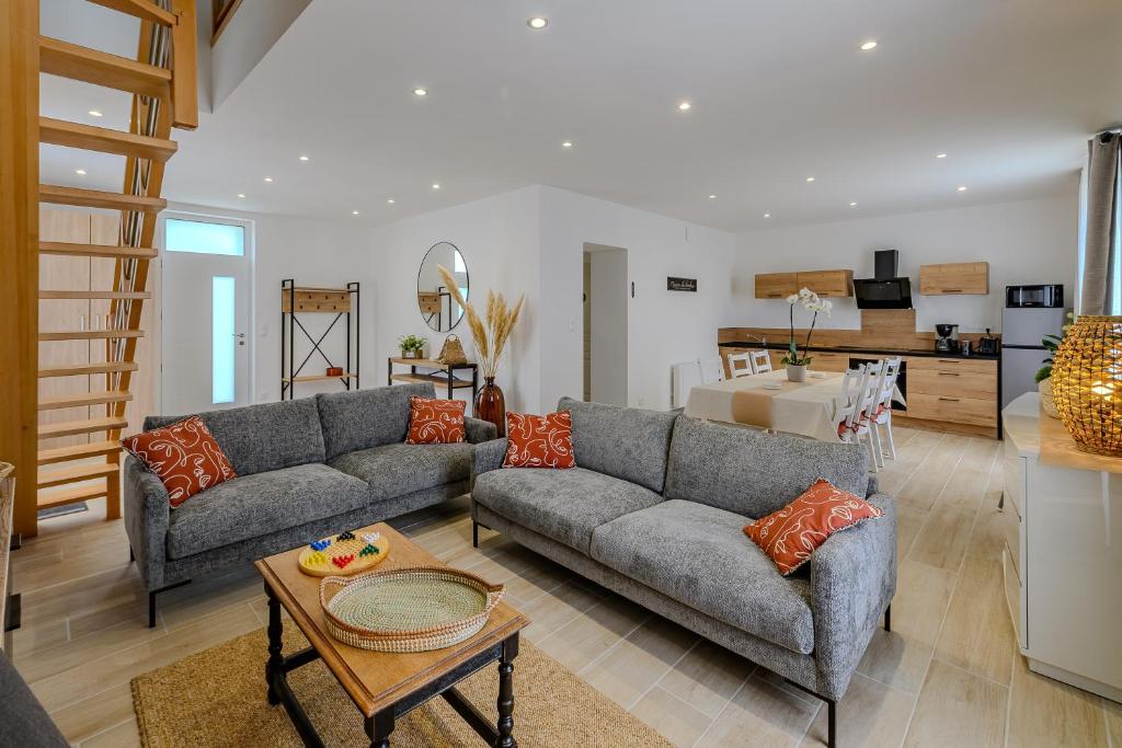 un salon avec deux canapés et une cuisine dans l'établissement La Maissemiacoise - Belle Maison de campagne, à Maissemy