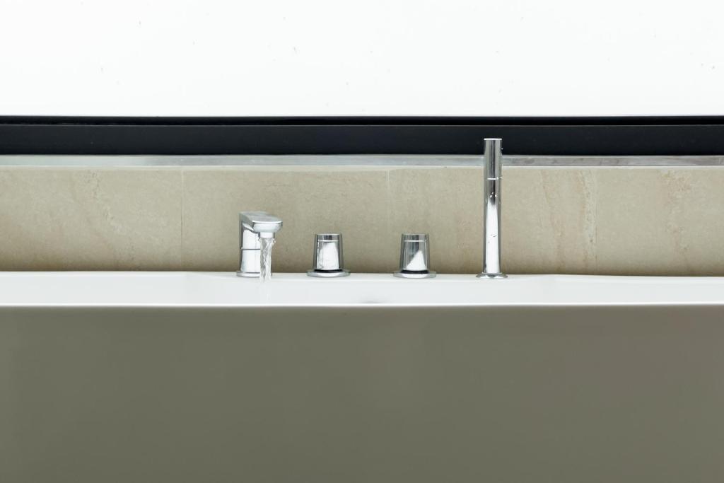 a sink with three faucets in a bathroom at Stephanie villa by fisherman Village in Nathon Bay