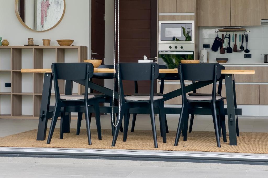 a dining room table and chairs in a kitchen at Stephanie villa by fisherman Village in Nathon Bay