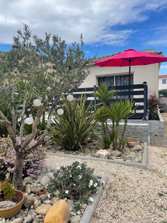 une maison avec un parapluie rose et quelques plantes dans l'établissement Saint-Cyprien Maison de standing, à Saint-Cyprien