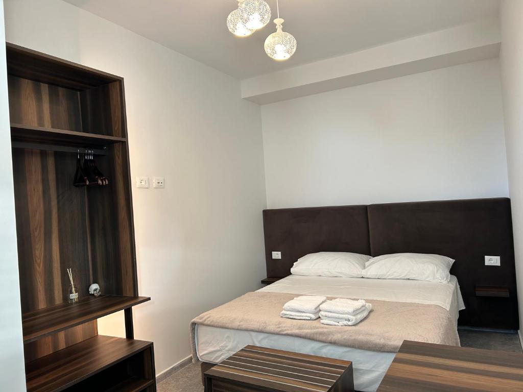 una camera da letto con un letto con due asciugamani sopra di OLEA Family Apt with Garden a Dhërmi