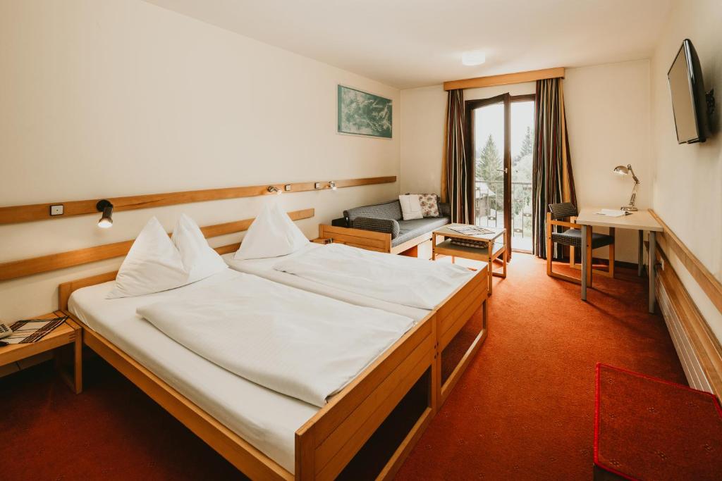 A bed or beds in a room at Hotel Kernwirt