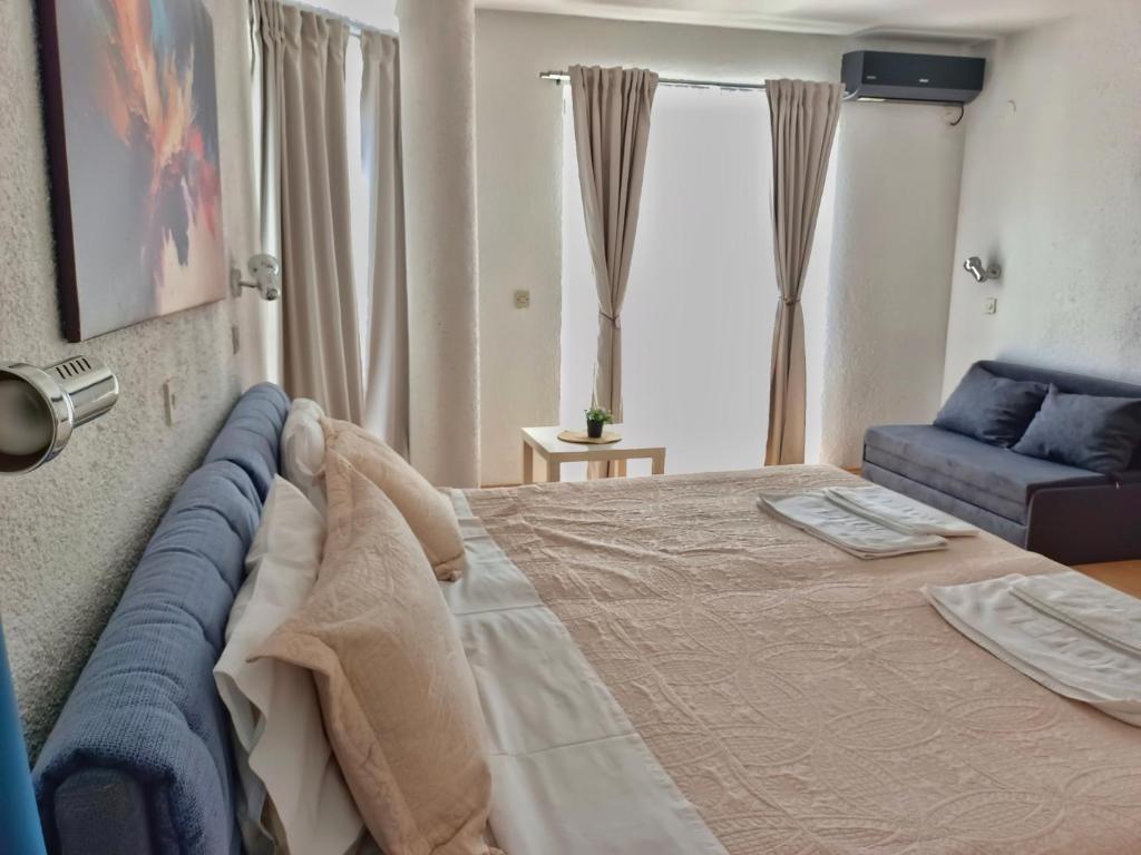 Un dormitorio con una cama grande y un sofá. en Apartments Gugoski, en Ohrid