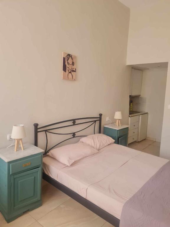 a bedroom with a bed with two nightstands and two lamps at lacasadirigas in Lefkada