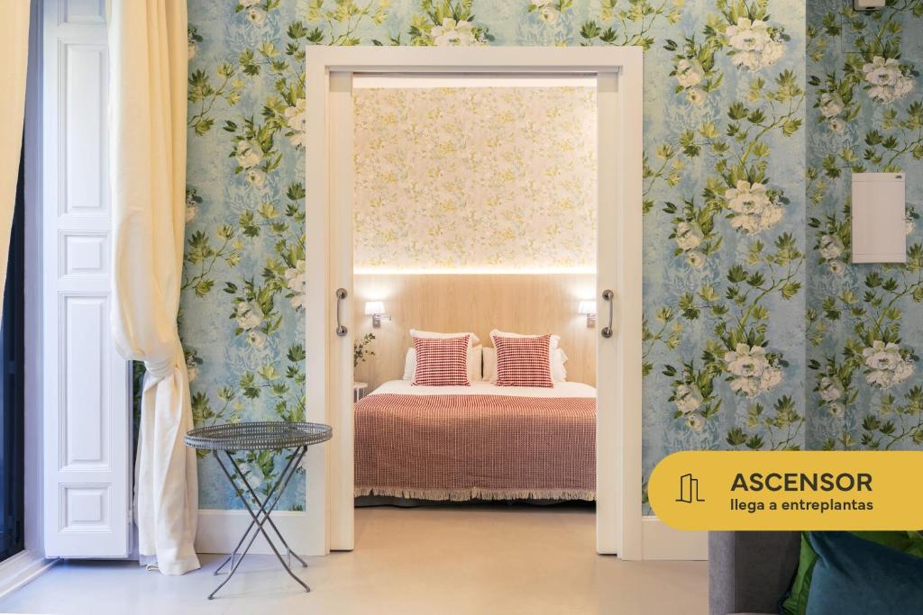 a bedroom with a bed with blue and white wallpaper at Feelathome San Marcos Apartments in Madrid