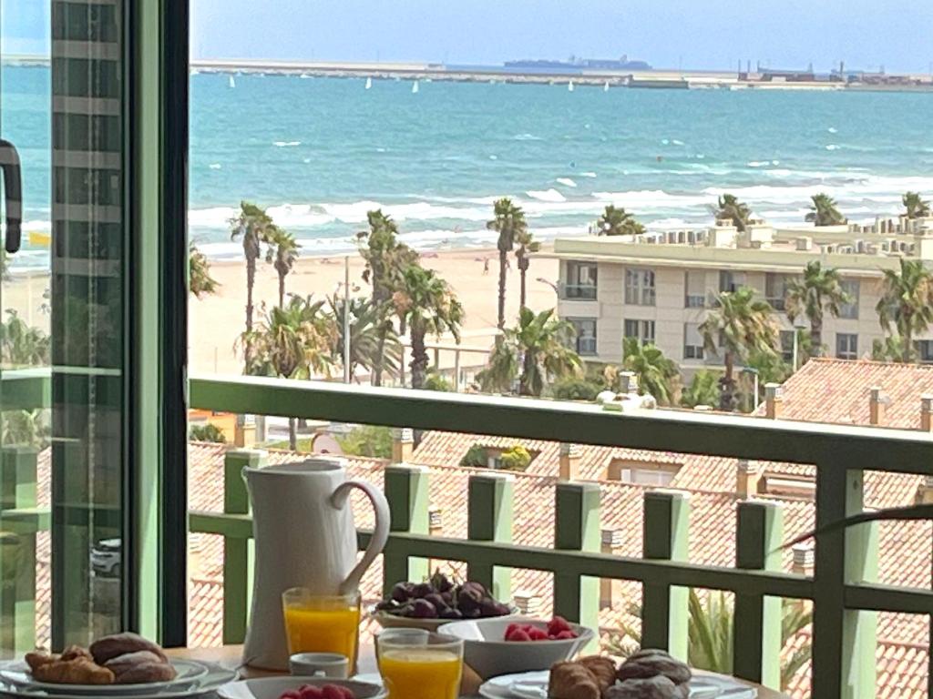 un tavolo con cibo e vista sulla spiaggia di Stylish well-connected beachfront flat a Valencia