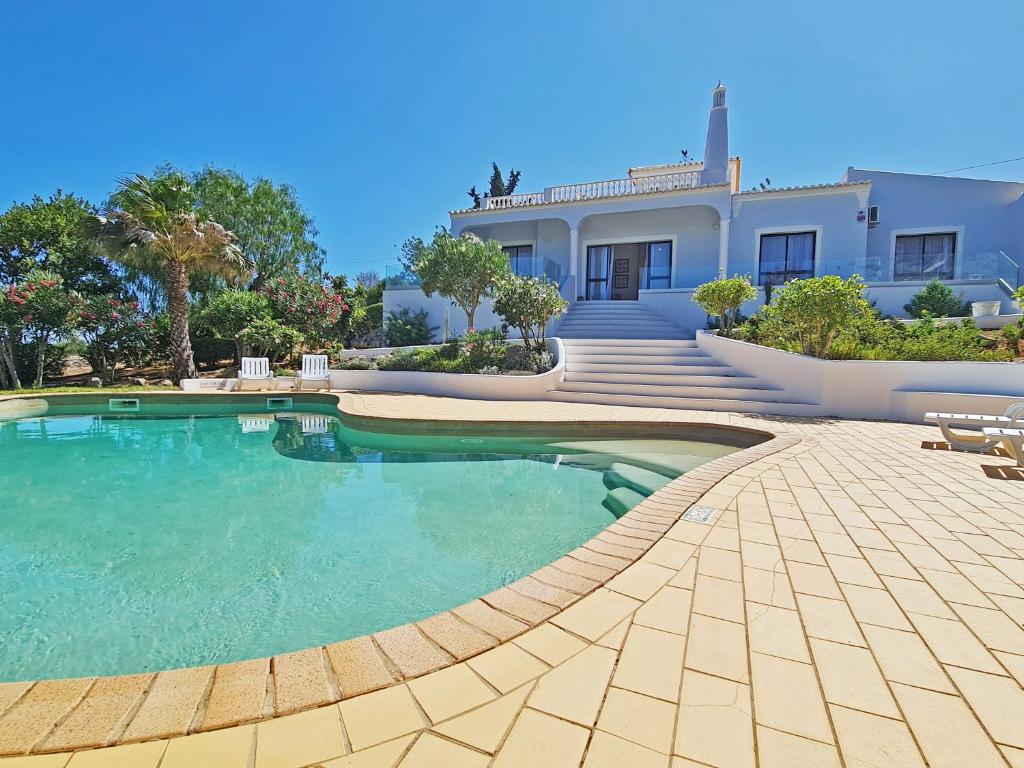 a large swimming pool in front of a house at Casa Vitória - with private pool in Pêra