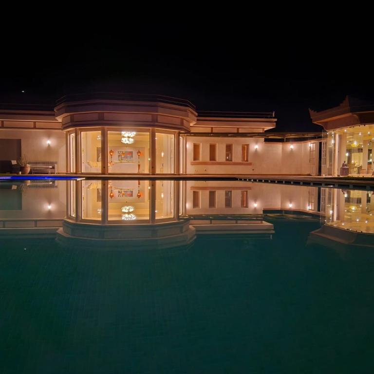 a house with a swimming pool at night at Domaine Lamrah in Marrakesh