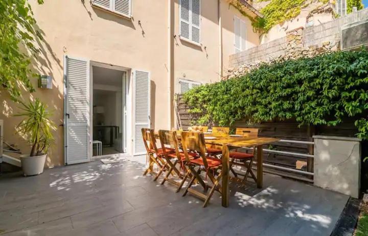 une table et des chaises en bois sur une terrasse dans l'établissement BEAU REZ DE JARDIN- Cannes Suquet - Clim- Calme - Lumineux- 15 minutes Palais des Festival, à Cannes