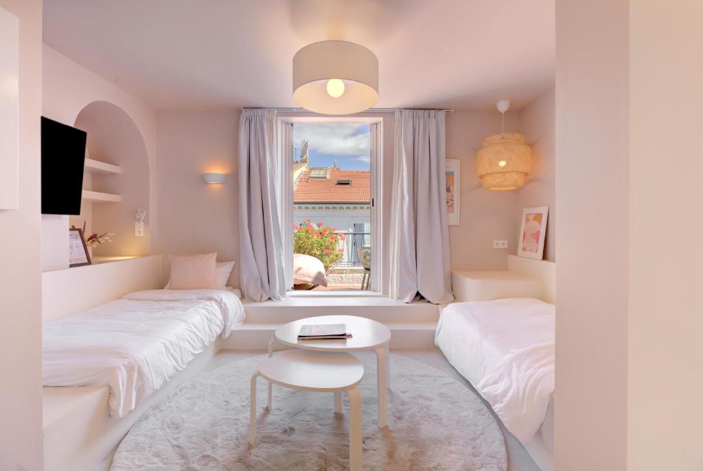Cette chambre blanche dispose de deux lits et d'une fenêtre. dans l'établissement Alma Florian apartment 4 people with terrace, à Cannes