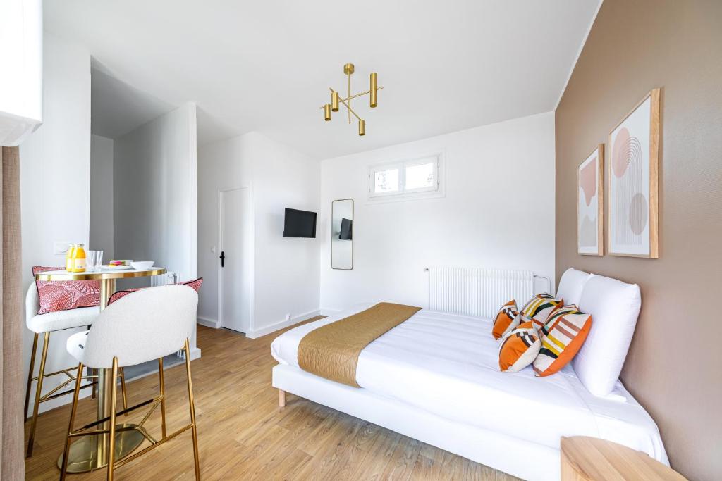 une chambre blanche avec un lit et un bureau dans l'établissement Studio Banlieue Parisienne - Issy-les-Moulineaux, à Issy-les-Moulineaux