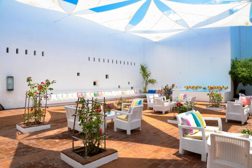 um quarto grande com cadeiras brancas e flores em The Lince Ecorkhotel Évora em Évora