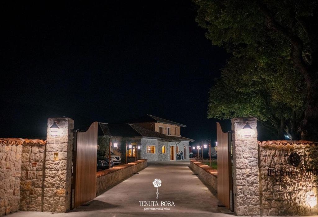a gate leading to a house at night at TENUTA ROSA - Gastronomia e Relax in Montesano Scalo