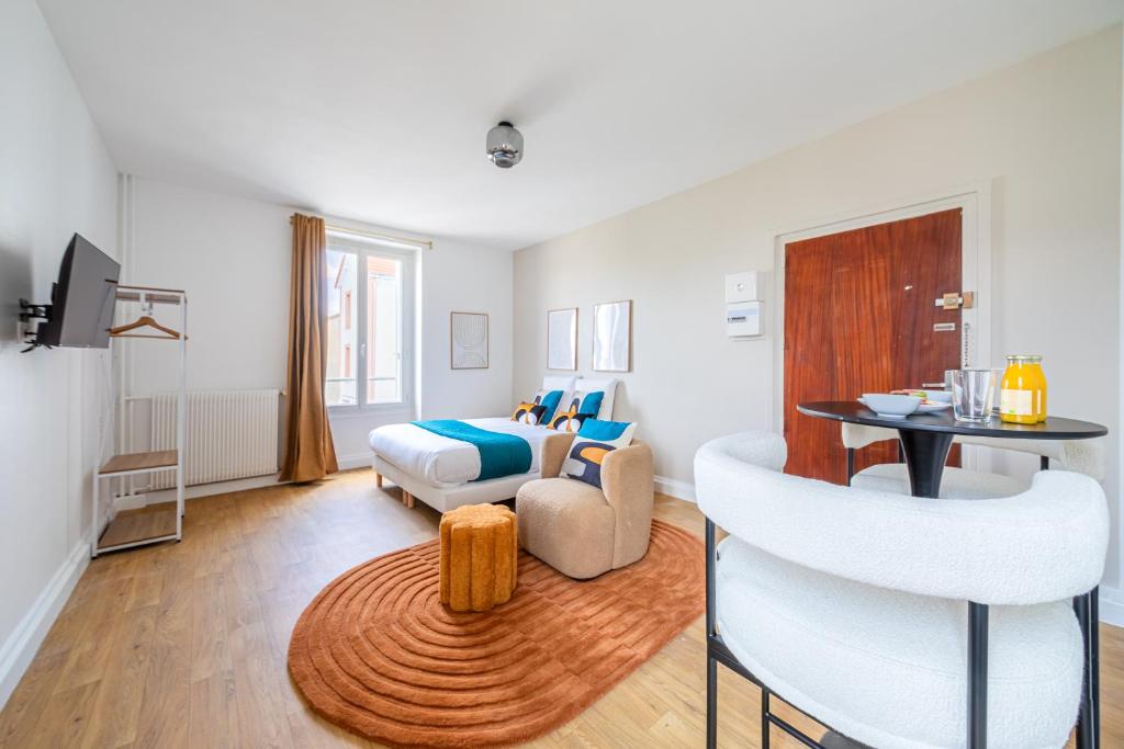 een slaapkamer met een bed, een tafel en een bank bij Magnifique studio proche de la capitale in Issy-les-Moulineaux