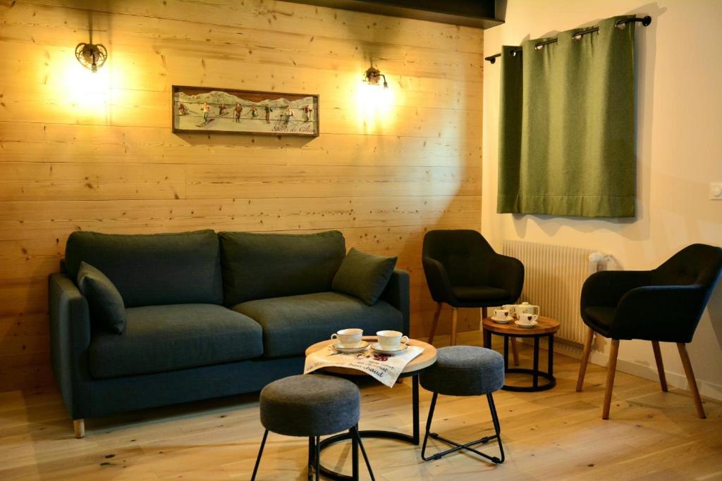 un salon avec un canapé, des chaises et une table dans l'établissement L'épicéa - Piscine et Spa, à Morillon