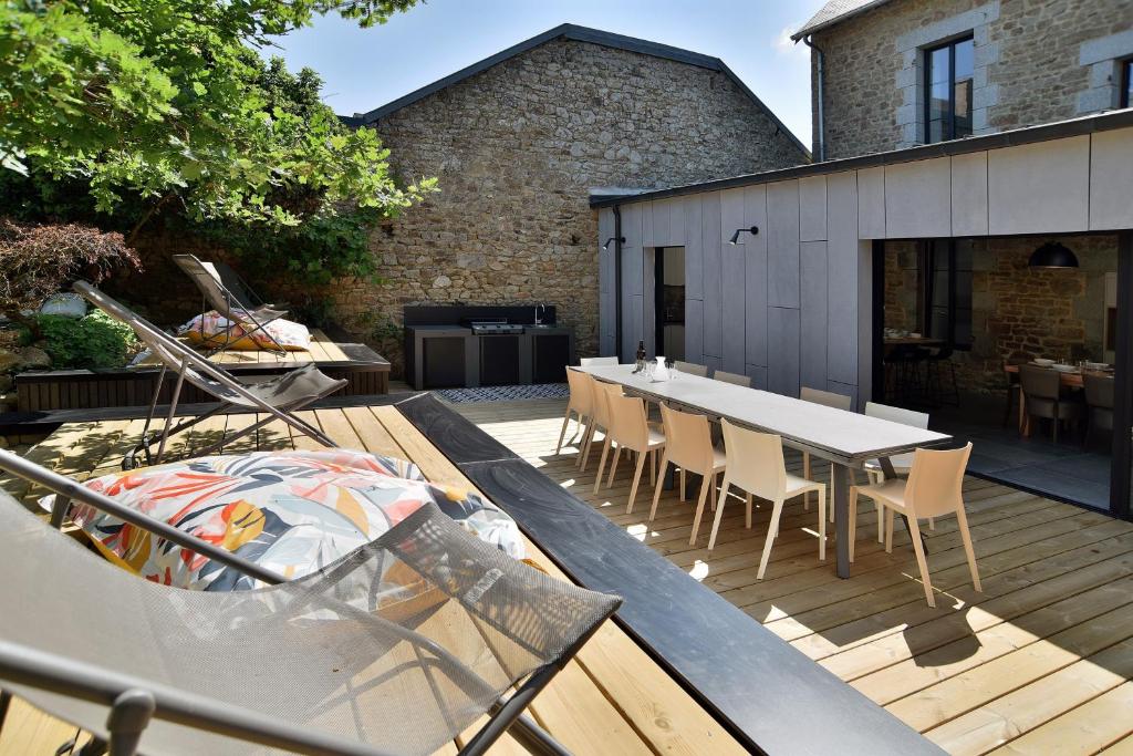 a patio with a table and chairs on a deck at La Villa des Fontenelles - Proche de la mer in Carolles