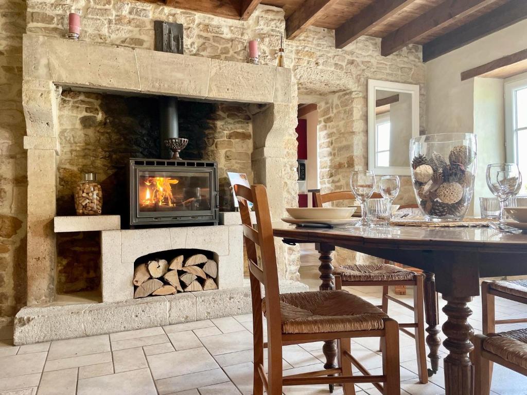 una sala da pranzo con camino e tavolo di Maison de pays proche de la mer a Fontenay-sur-Mer