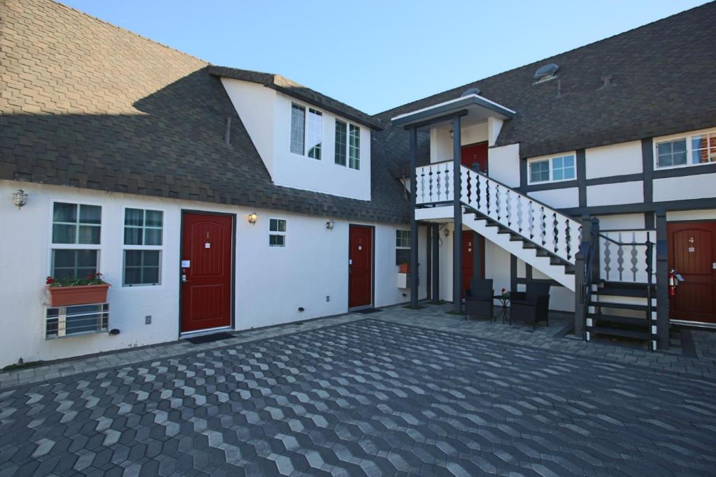 a group of buildings with red doors and a staircase at New Haven Inn in Solvang